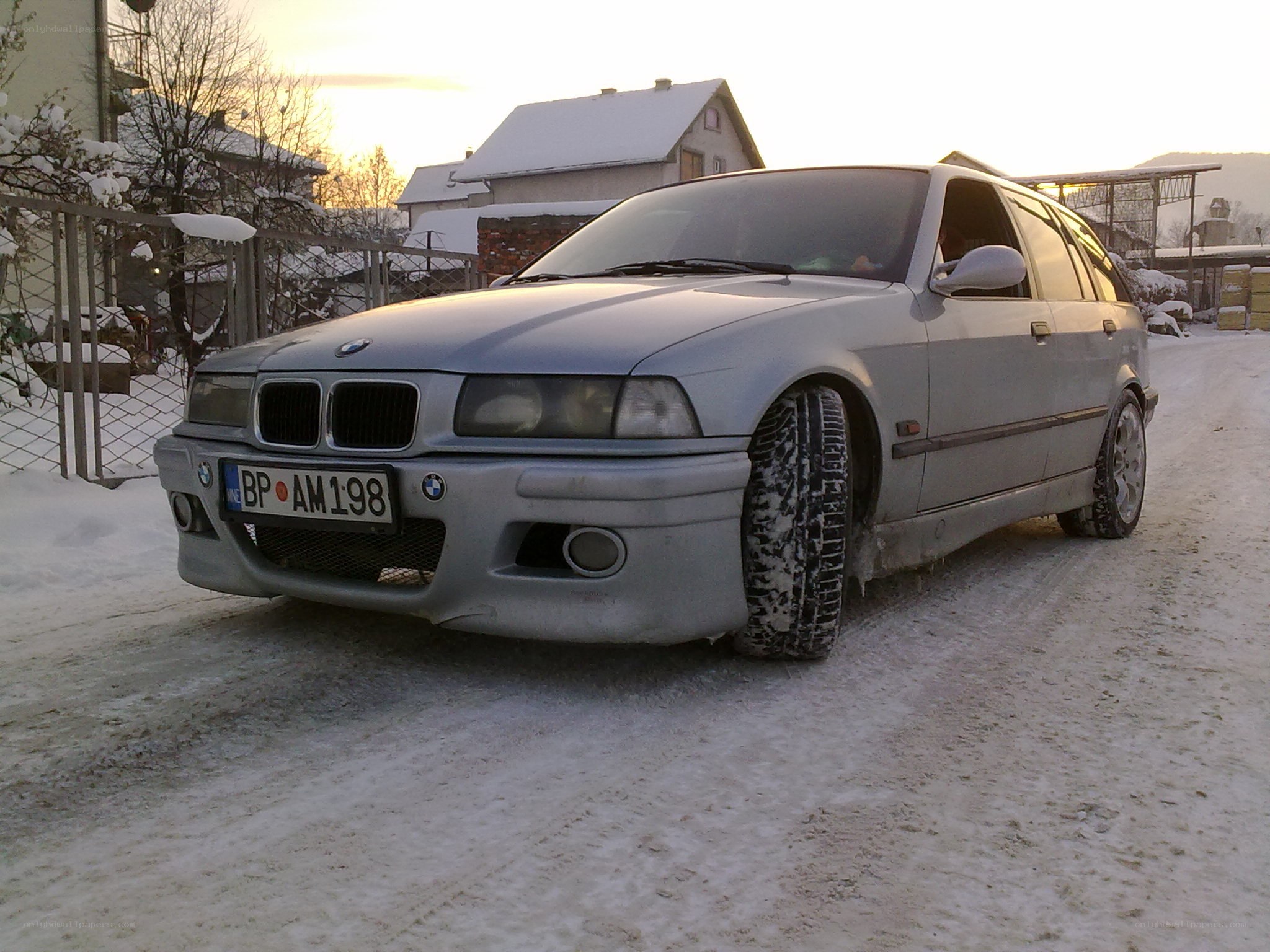Silver BMW in snowy driveway