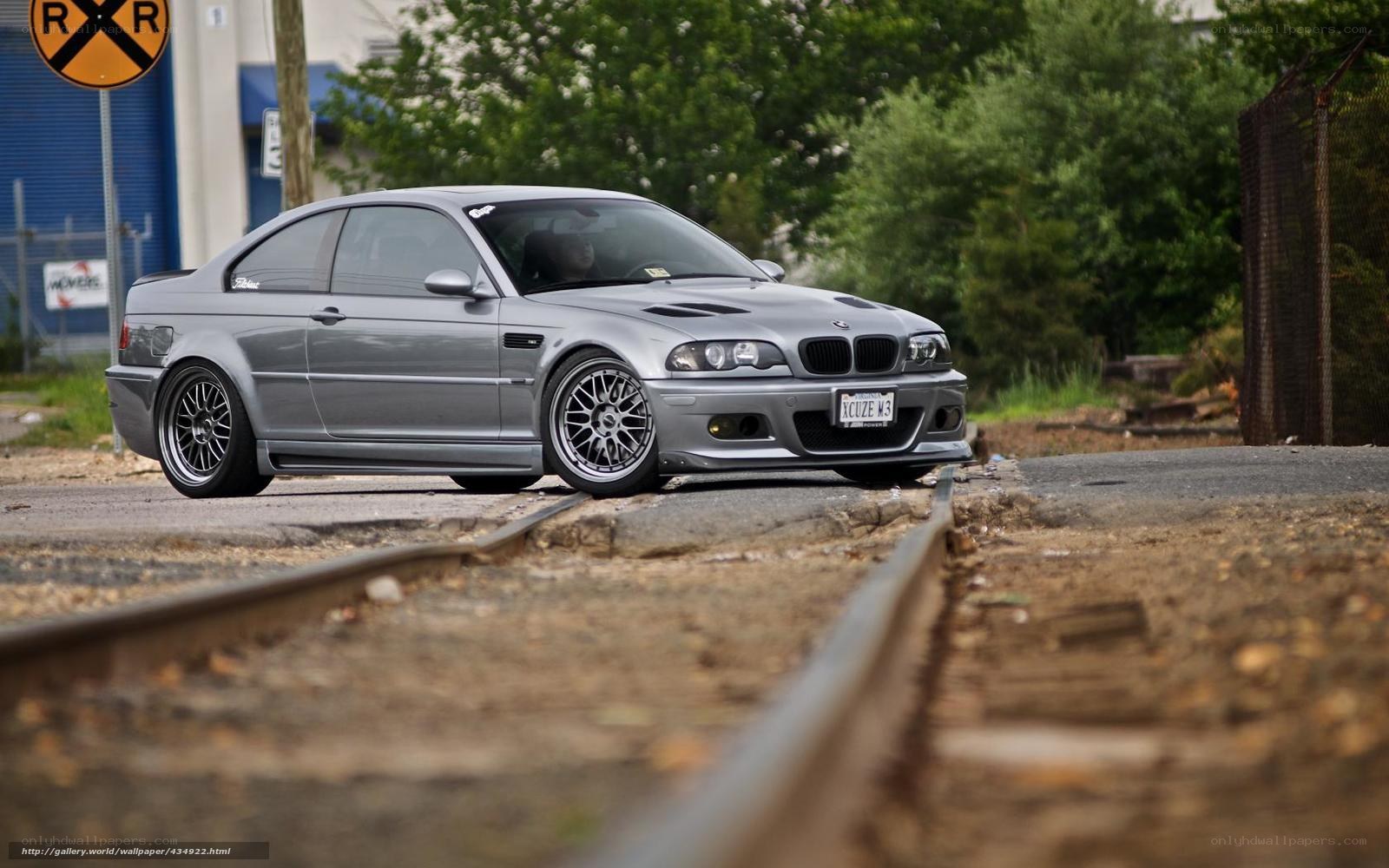 Silver BMW M3 on train tracks