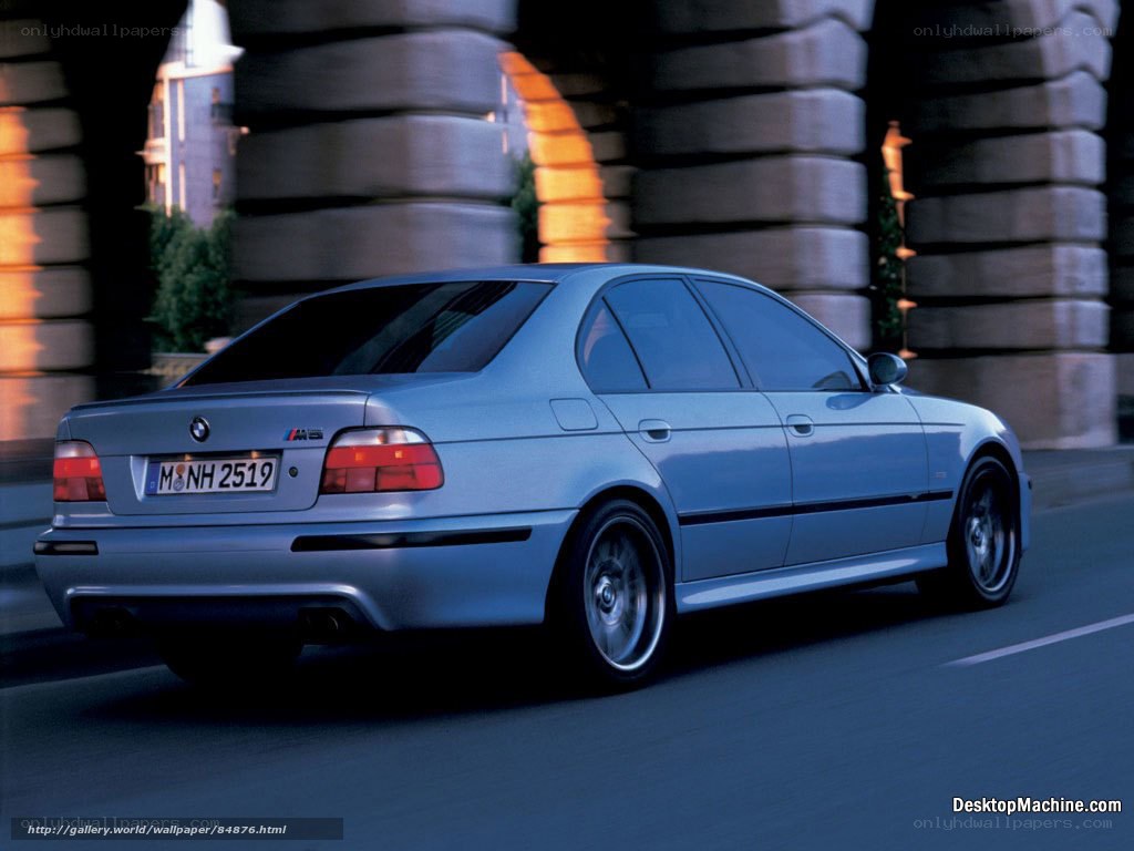 silver bmw m5 driving under bridge