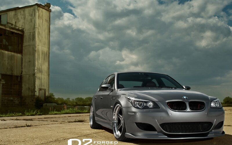 Silver BMW M5 in industrial setting