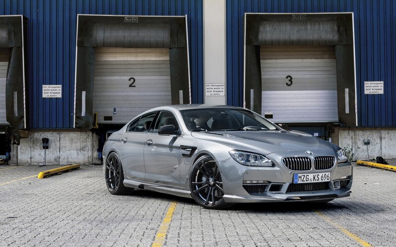 Silver BMW M6 in front of warehouse