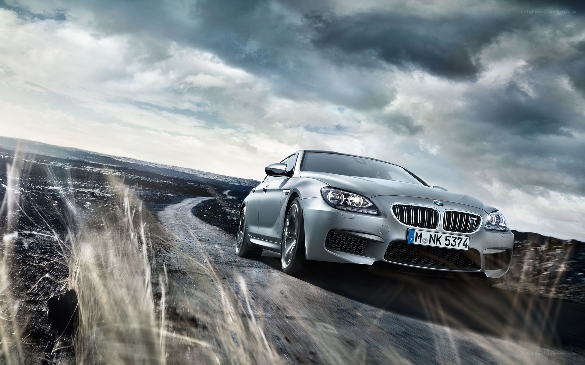 Silver BMW M6 on a dirt road