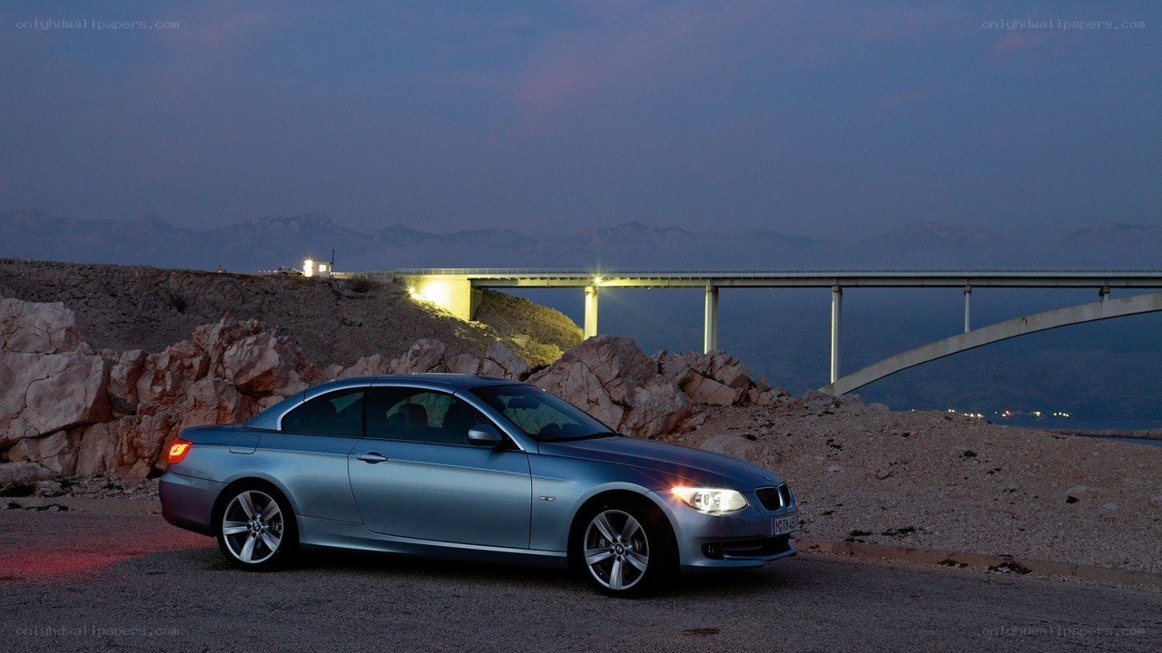 Silver BMW on a cliffside at dusk
