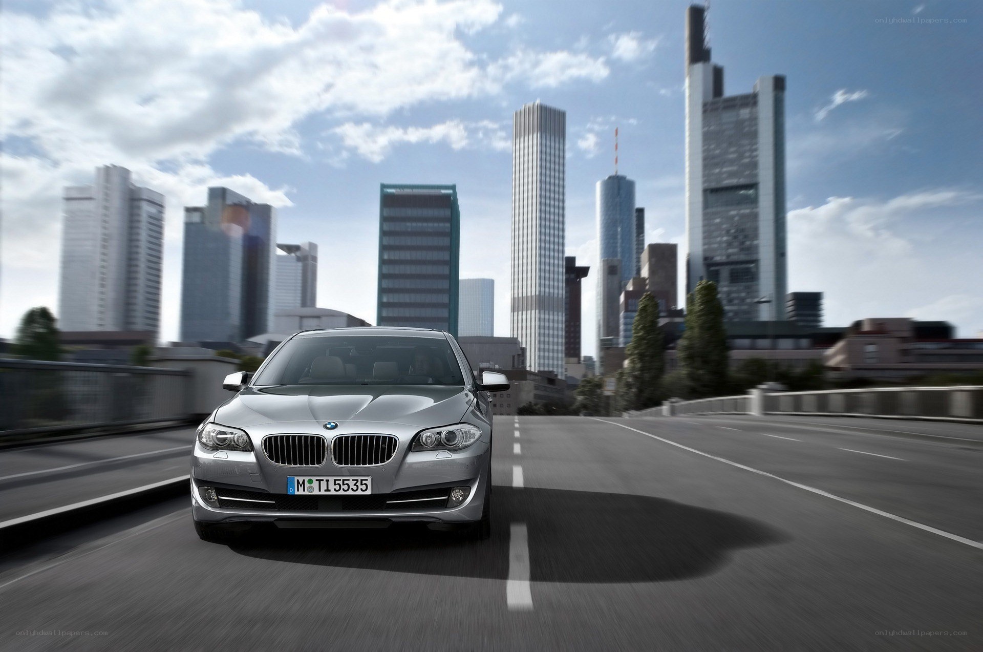 Silver BMW on city bridge