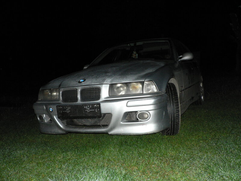 silver bmw on grass at night