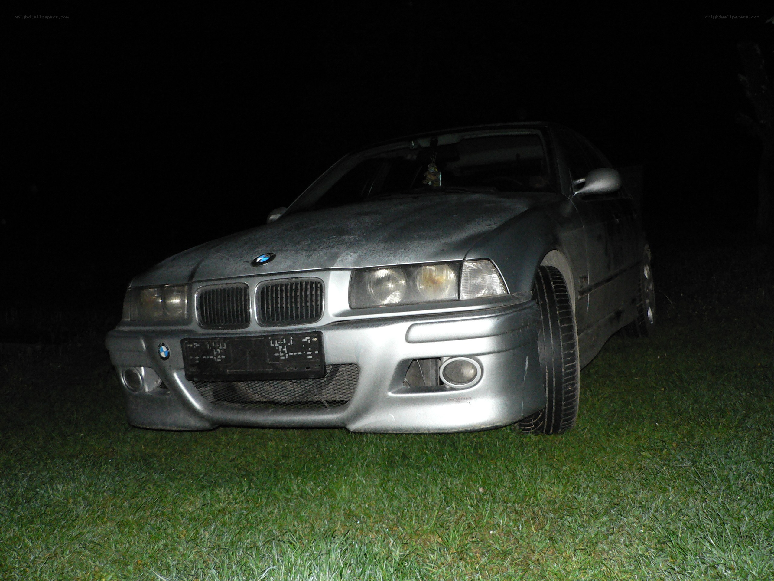 silver bmw on grass at night
