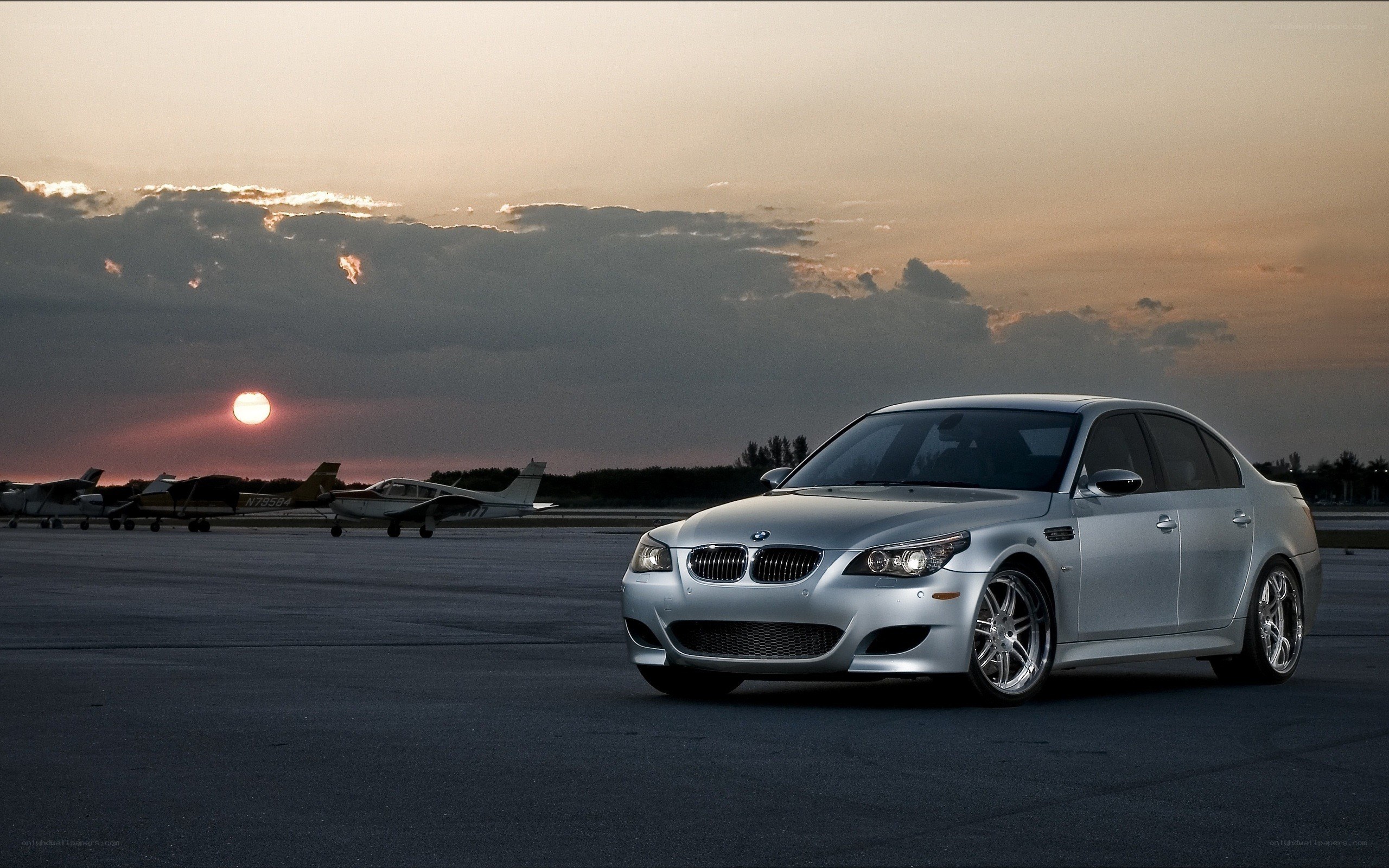 Silver BMW on tarmac at sunset
