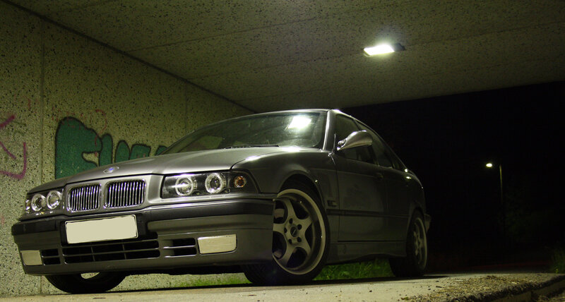 silver bmw parked under a bridge
