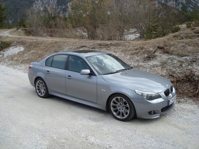 silver bmw sedan on gravel road