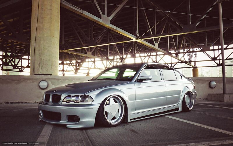 Silver BMW sedan under bridge