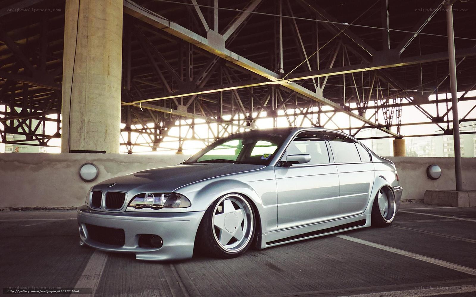 Silver BMW sedan under bridge