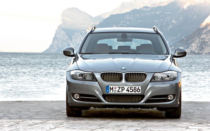 silver bmw station wagon by the sea