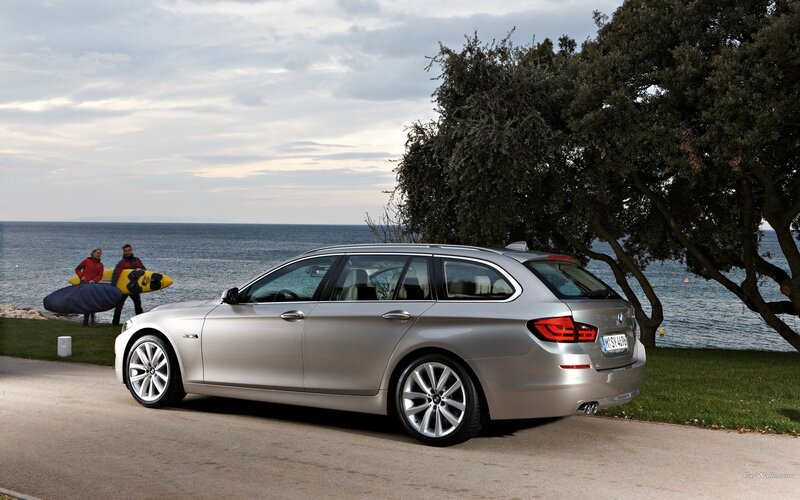 Silver BMW station wagon by the sea