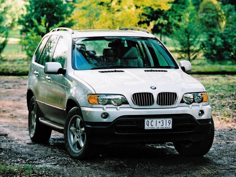 silver bmw suv on dirt road