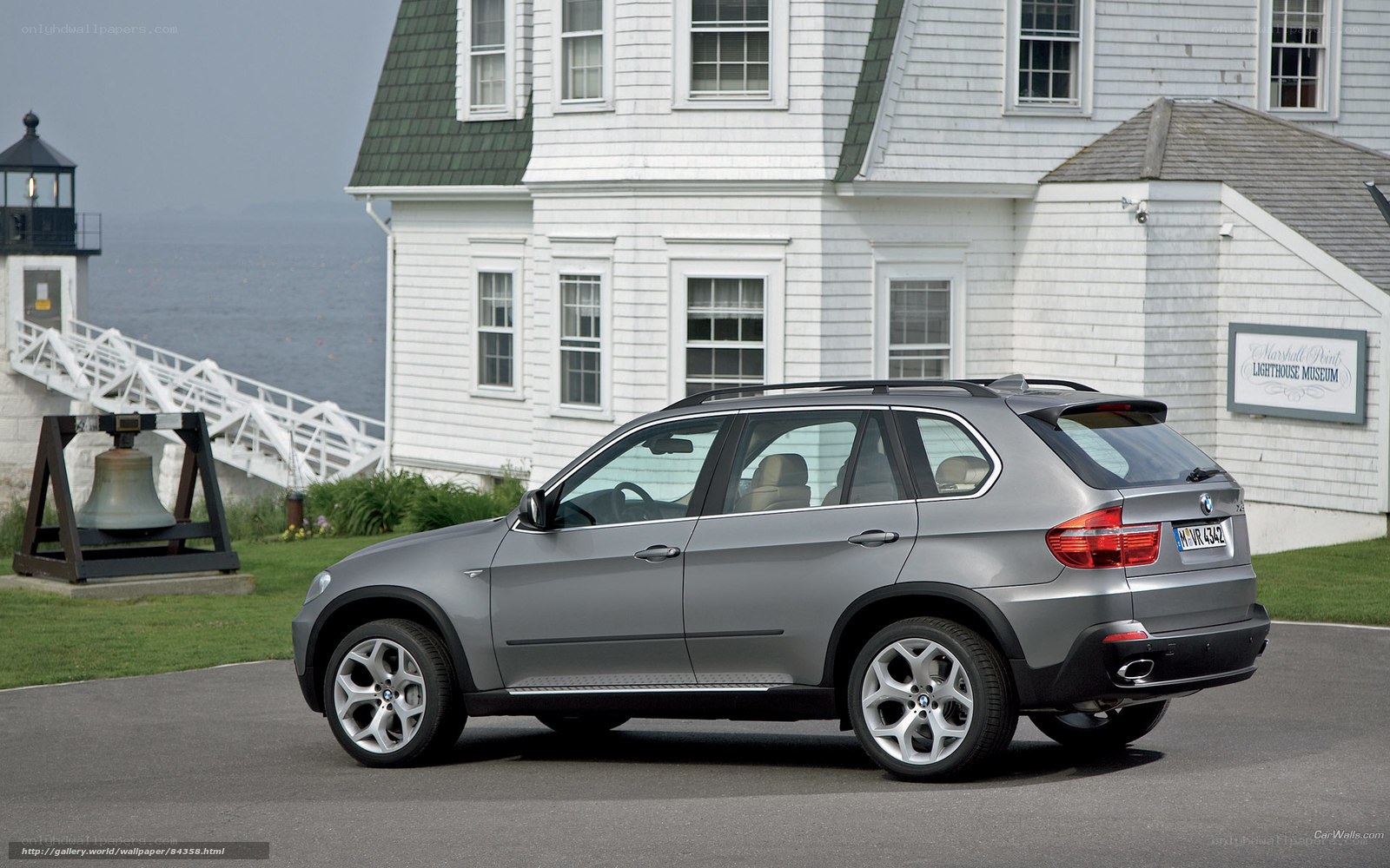 Silver BMW X5 by a lighthouse