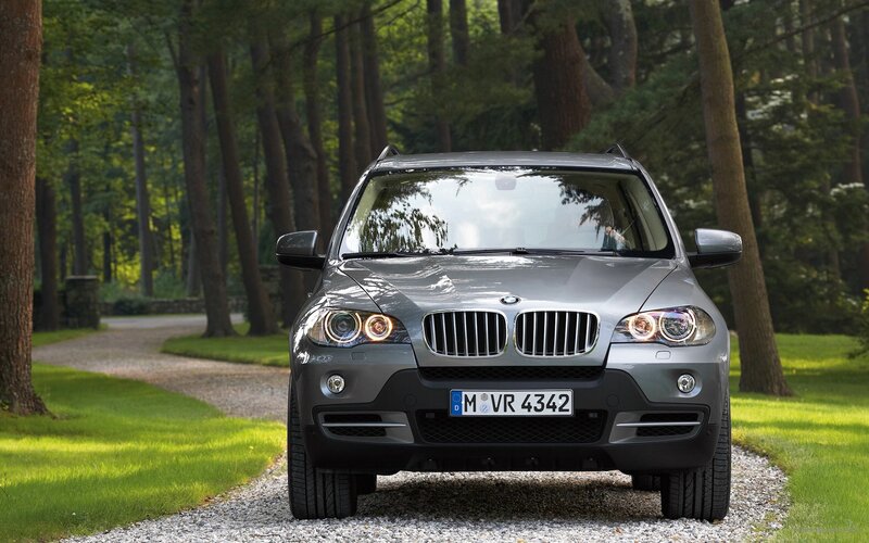 Silver BMW X5 in forest