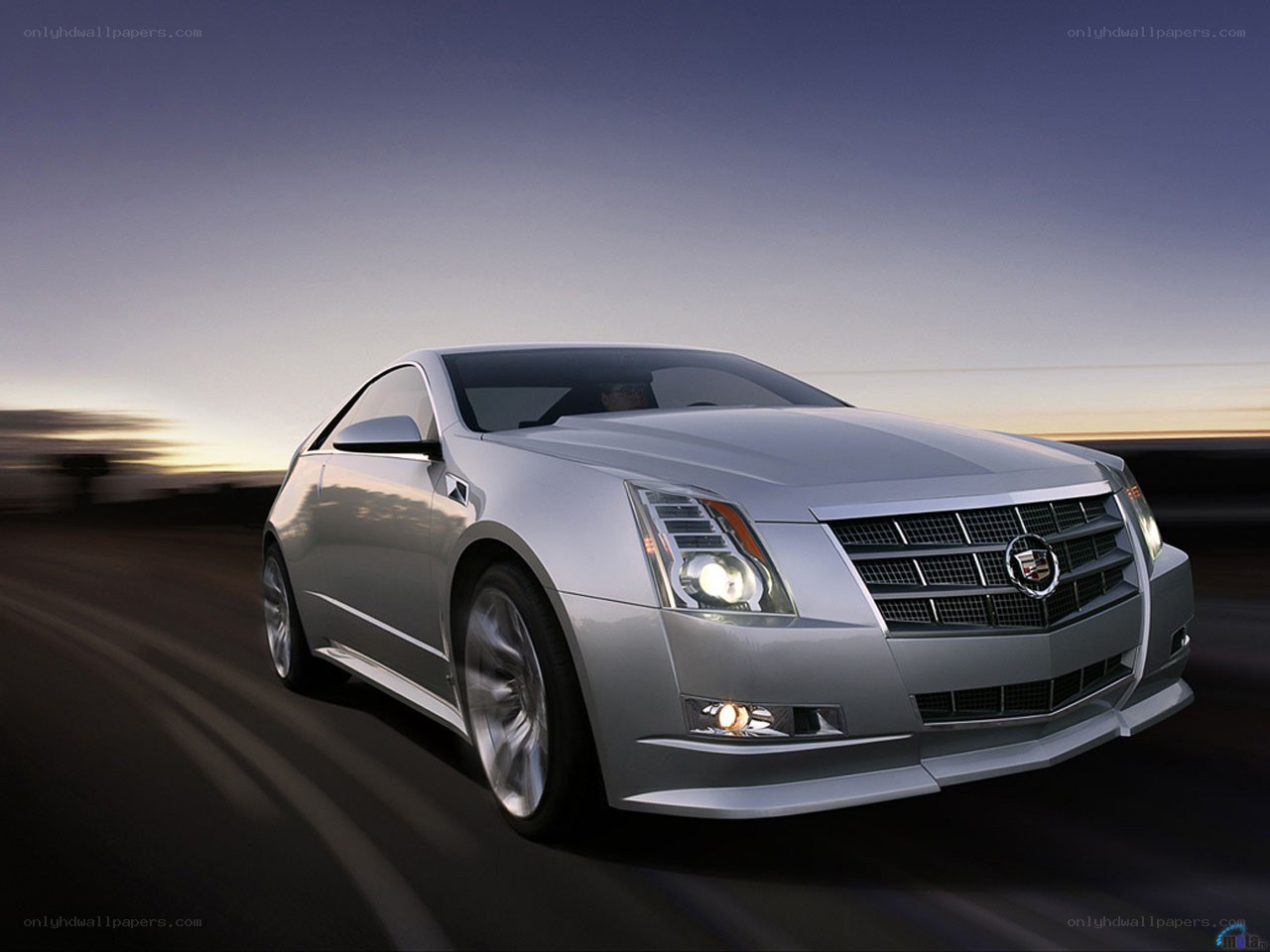 Silver Cadillac coupe in motion