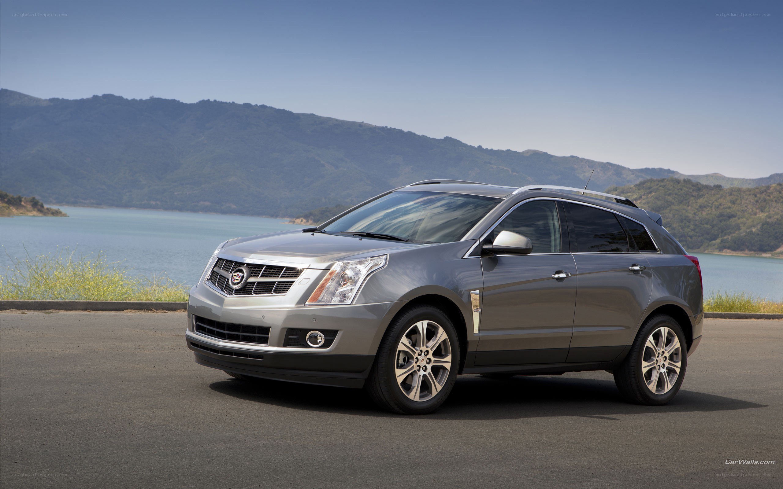 silver cadillac suv by lake