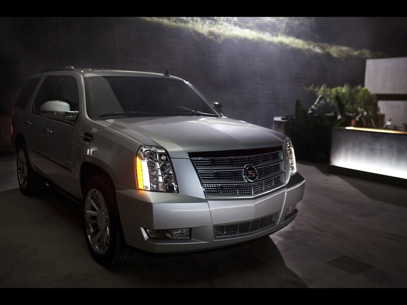 Silver Cadillac SUV in a dark setting