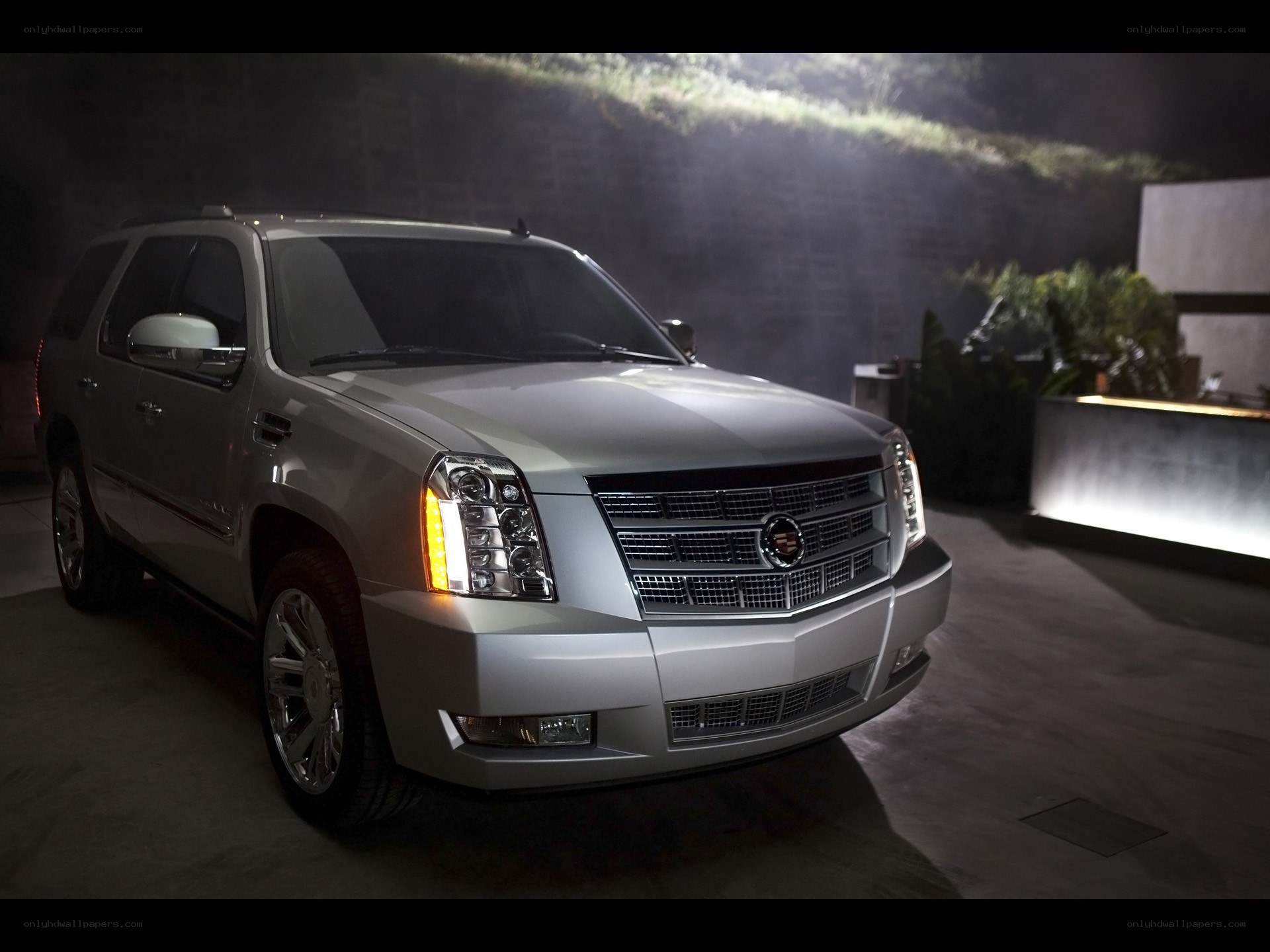 Silver Cadillac SUV in a dark setting
