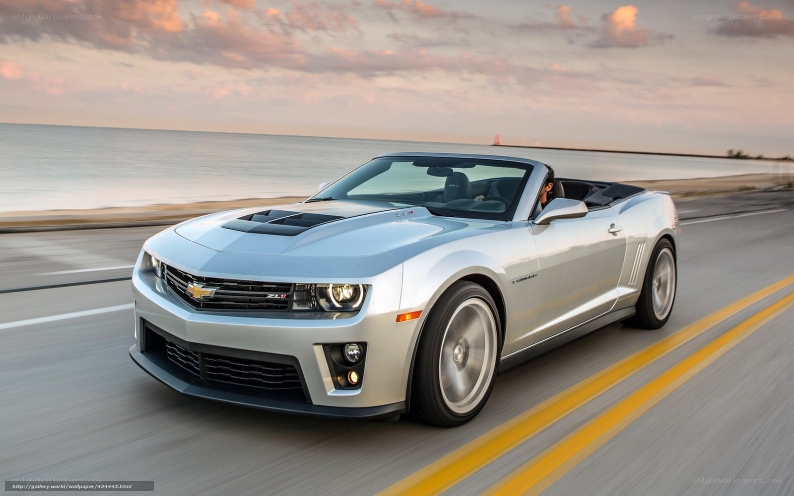 Silver Camaro convertible on coastal road