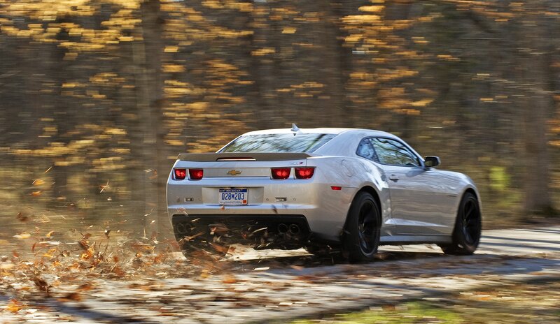 Silver Camaro driving on autumn road
