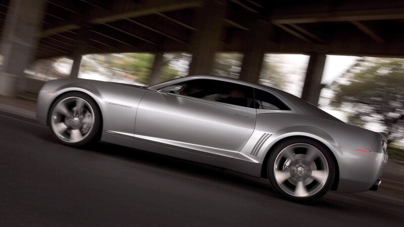 silver camaro driving under bridge