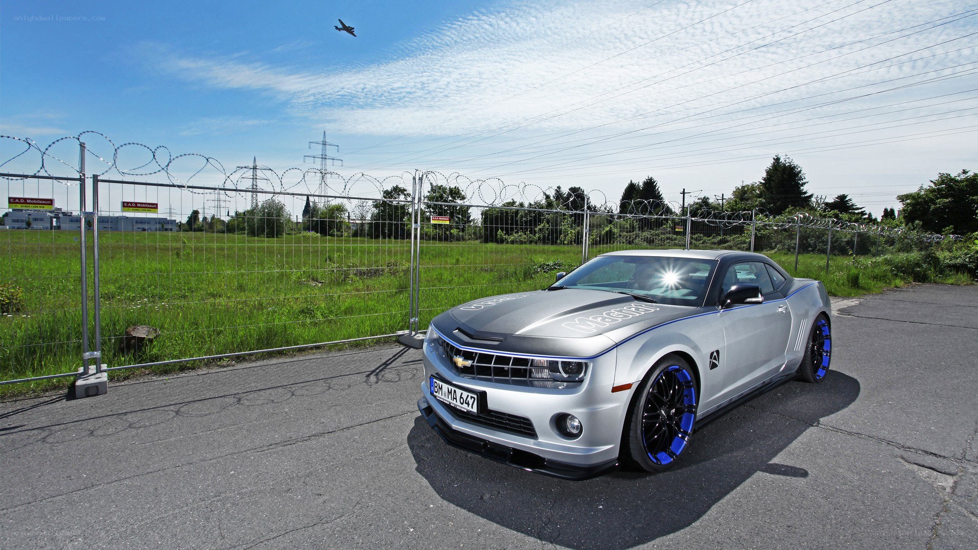 Silver Camaro on a paved lot