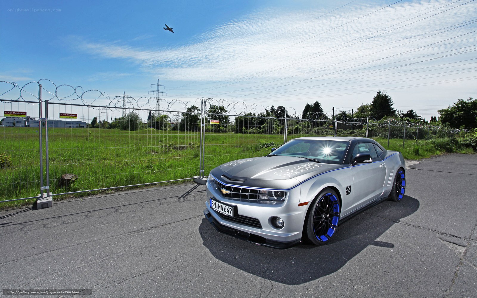 Silver Camaro on a paved lot