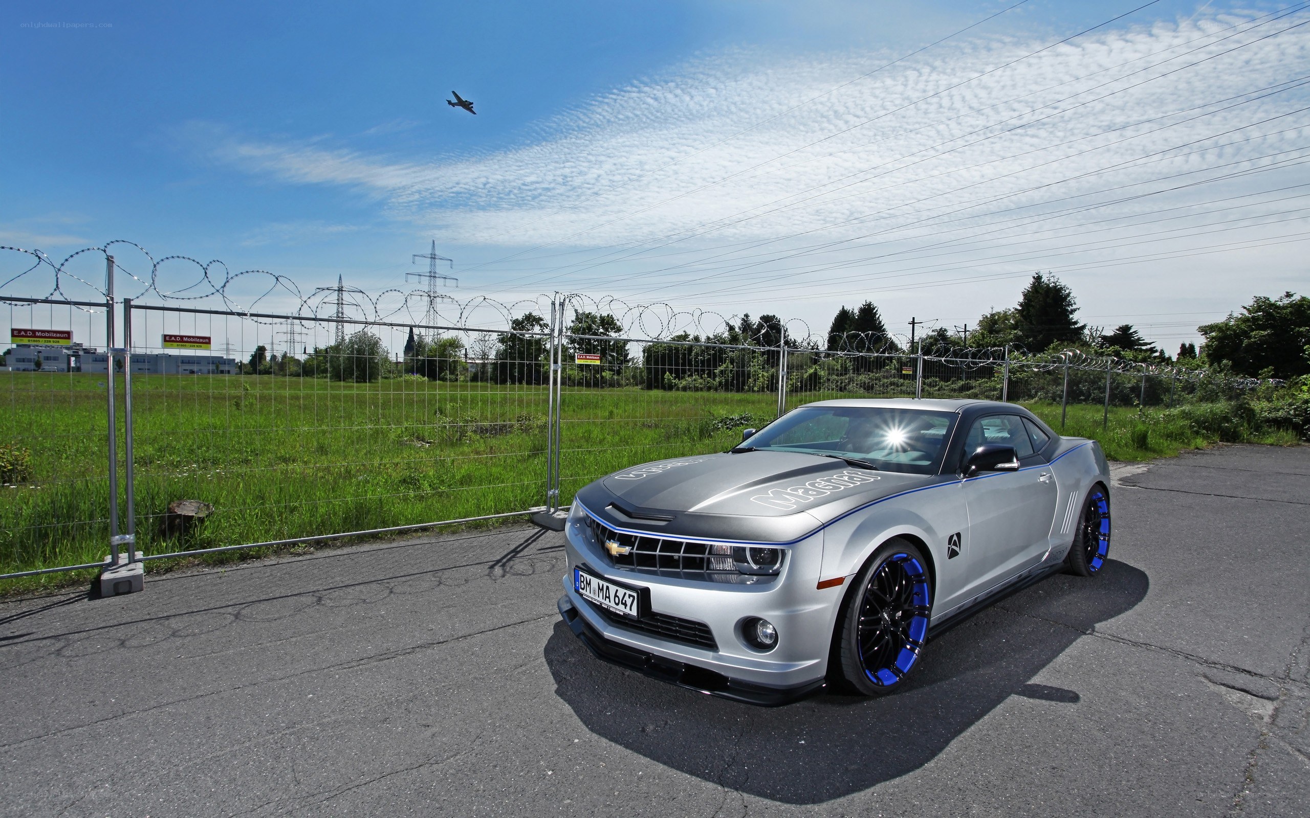 Silver Camaro with blue wheels