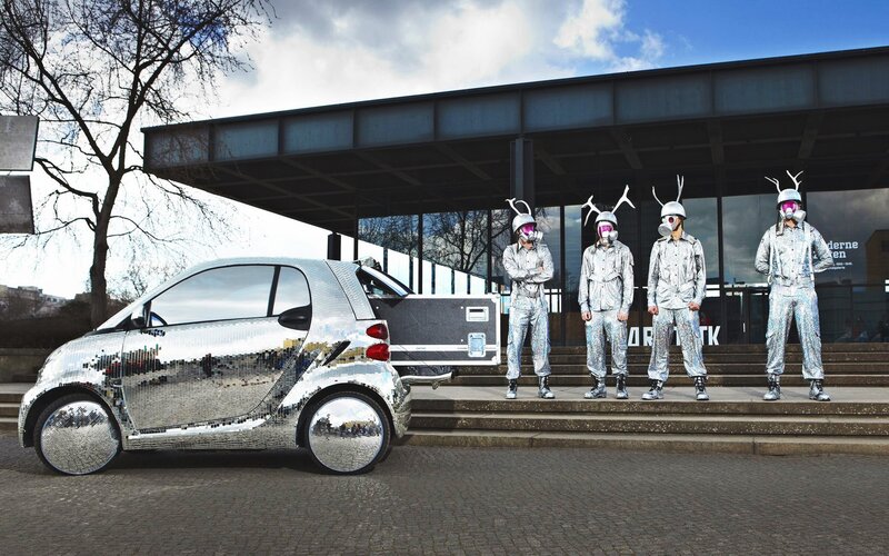 Silver car and costumed performers