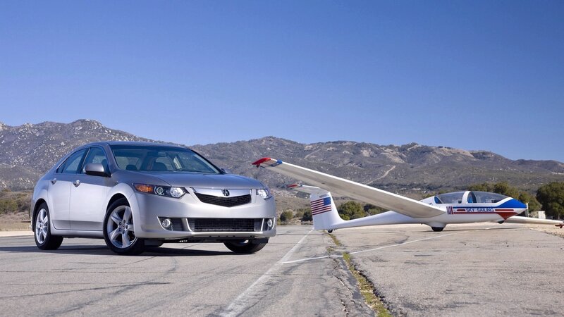 Silver car and glider on tarmac