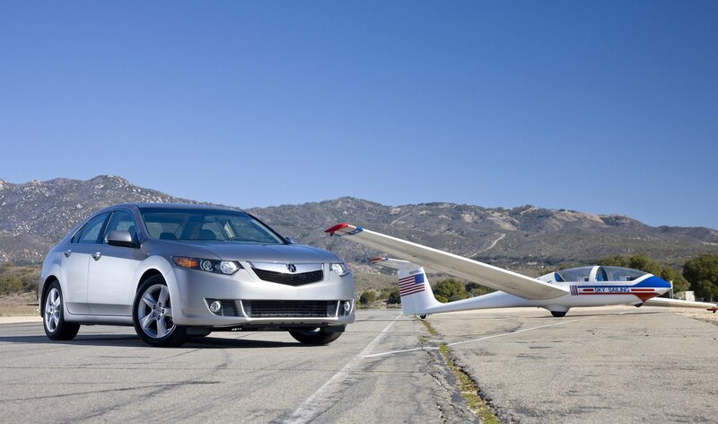 Silver car and glider on tarmac