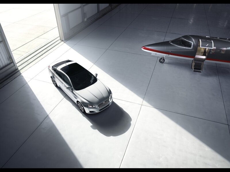 Silver car and private jet in hangar