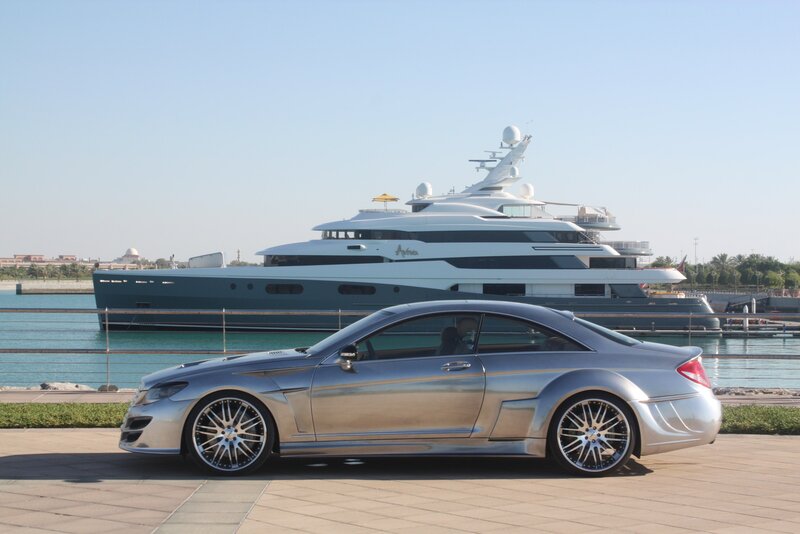 Silver car and yacht at marina