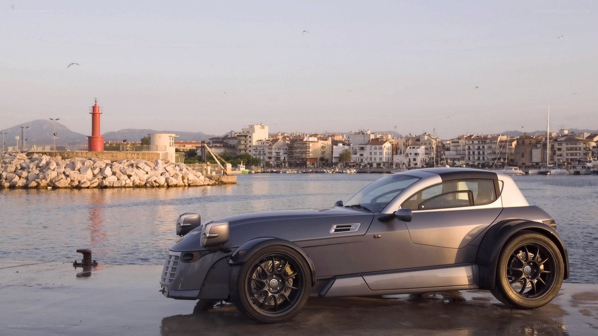 Silver car at a coastal harbor