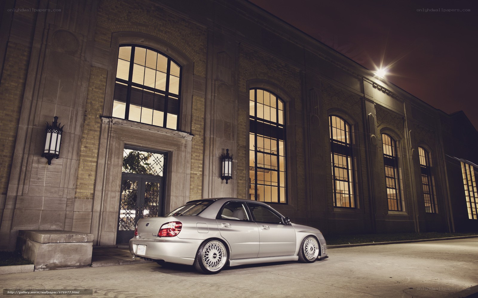 Silver car at night by building