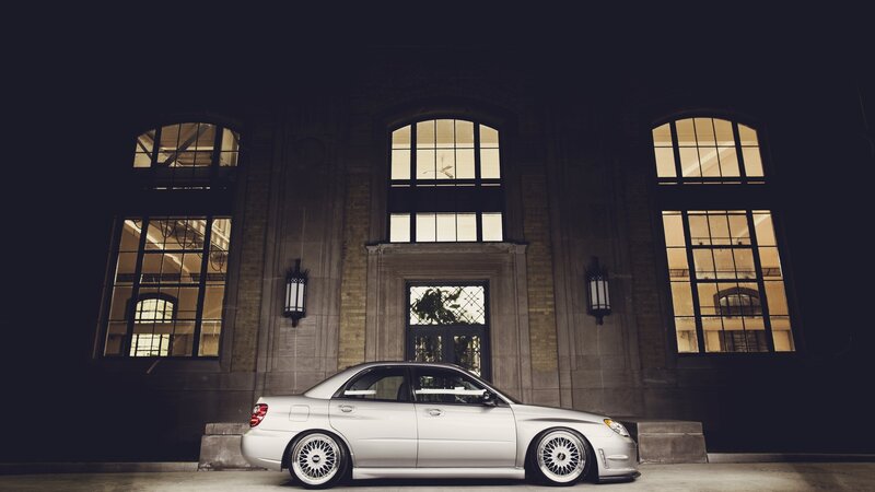 silver car at night in front of building