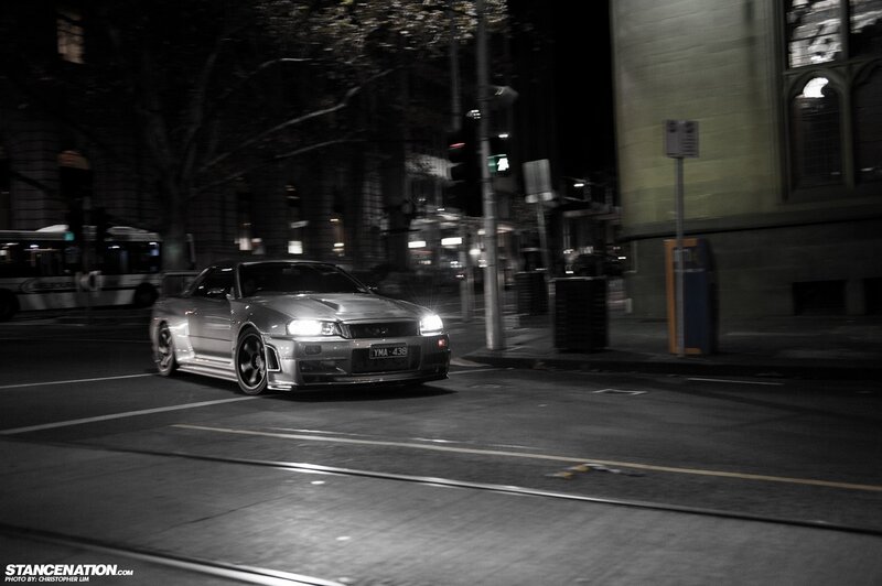Silver car at night on city street
