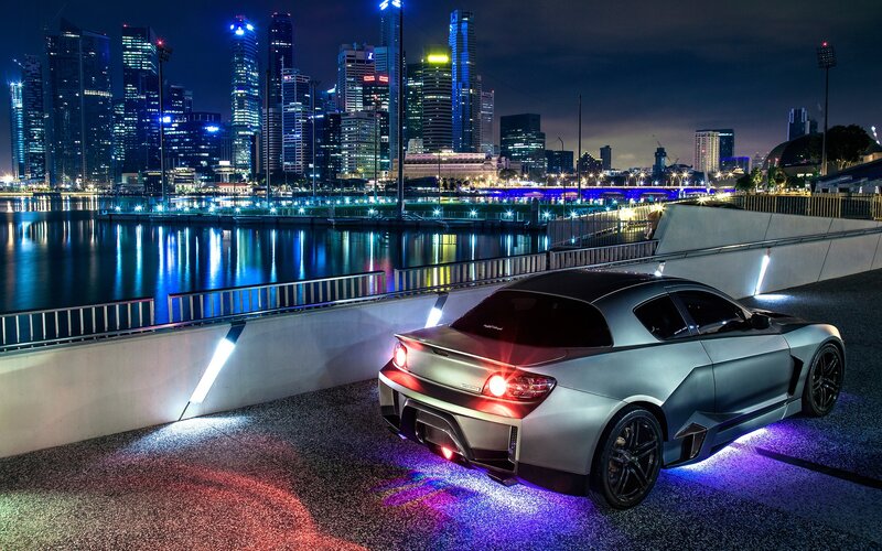 Silver car at night with city lights