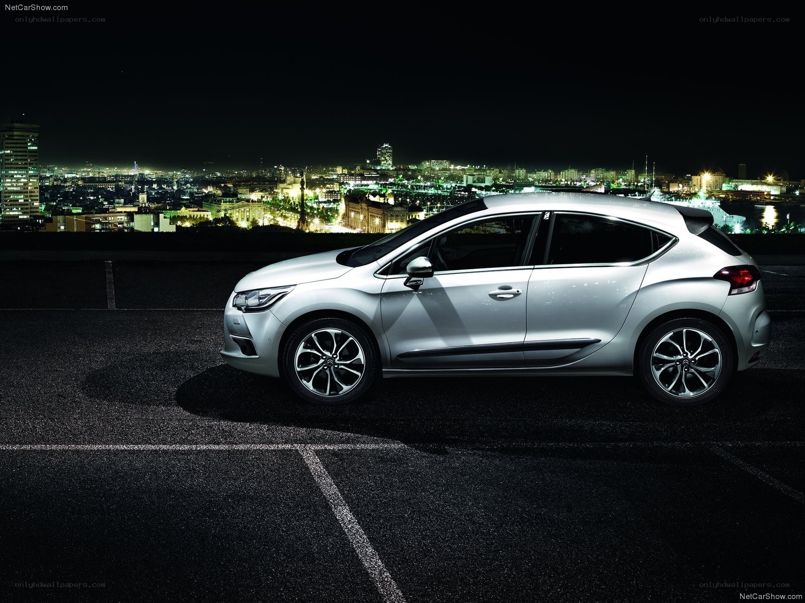 Silver car at night with city view