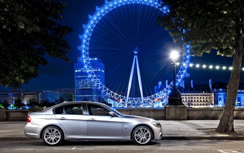 Silver car at night with London Eye