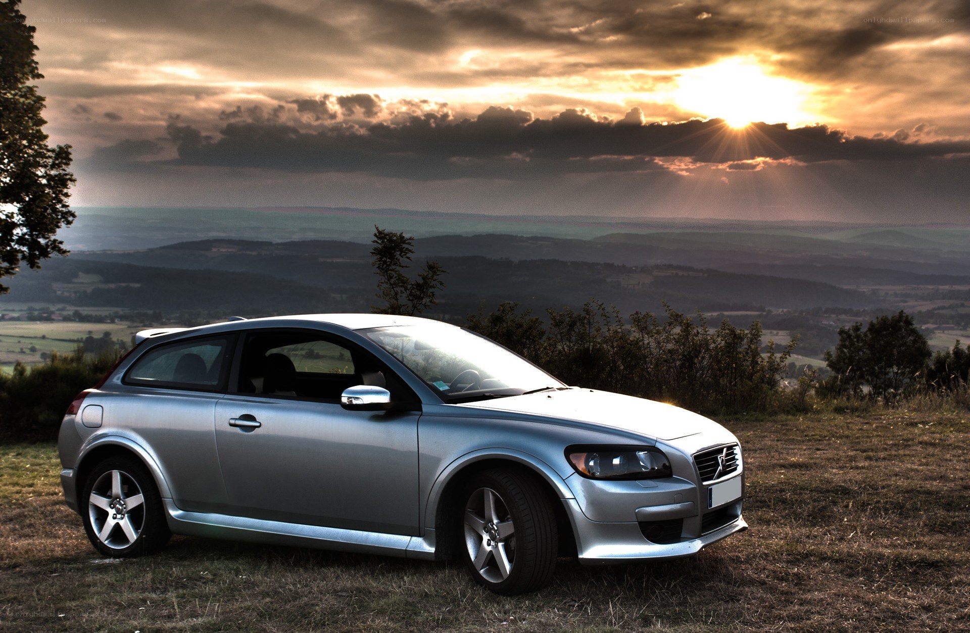 Silver car at sunset on hill