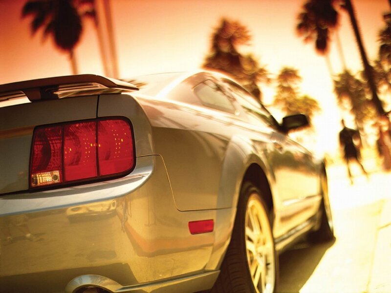 silver car at sunset with palm trees