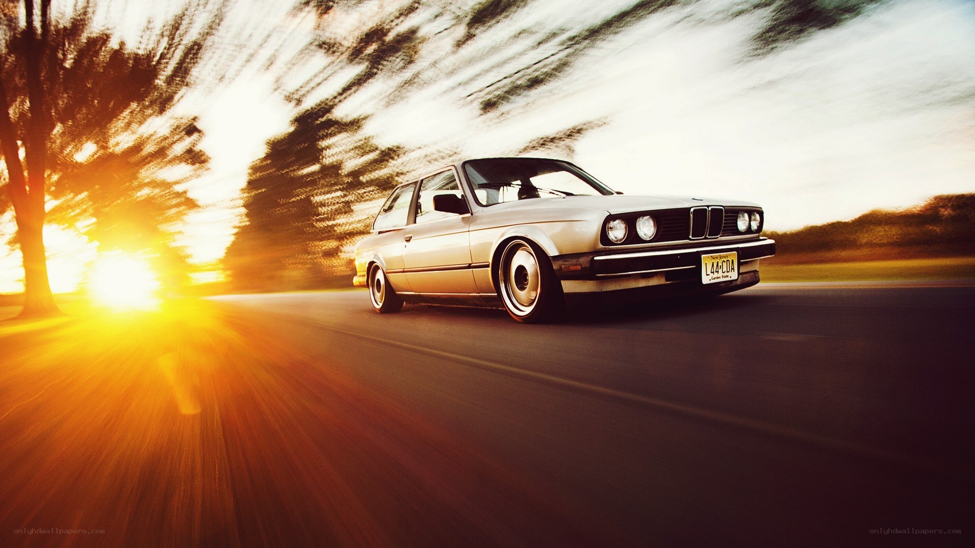 silver car driving at sunset