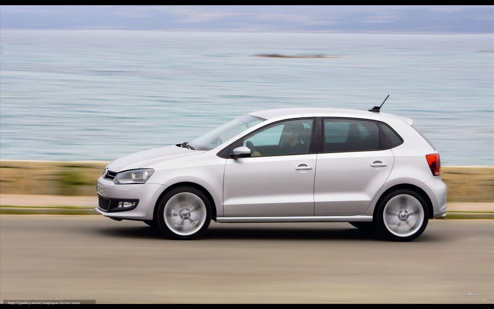 silver car driving by the sea