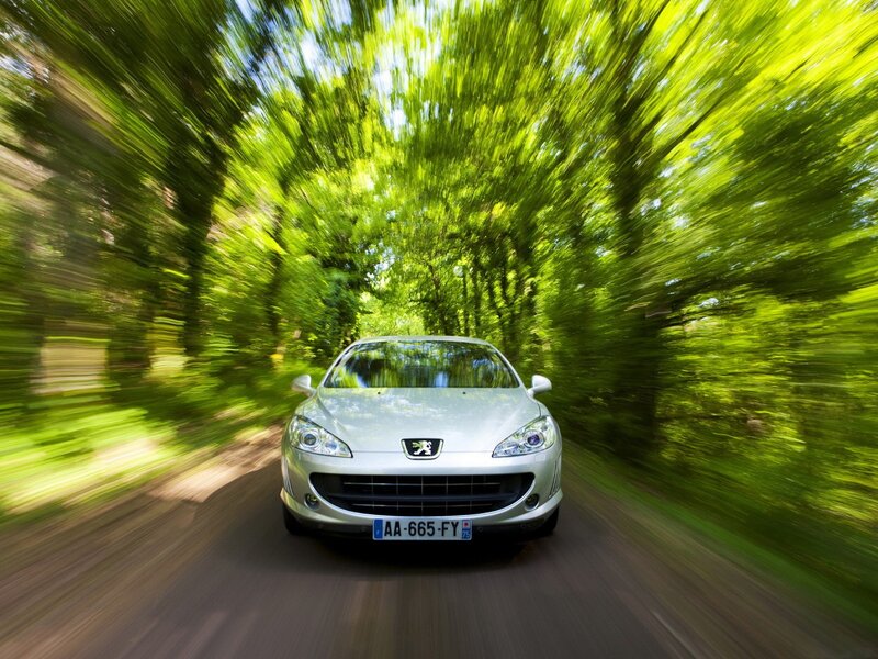 Silver car driving through forest