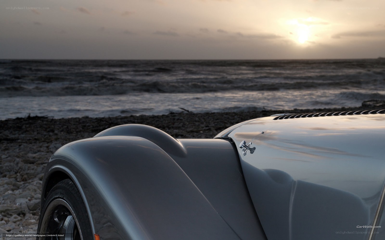 Silver car on a pebble beach