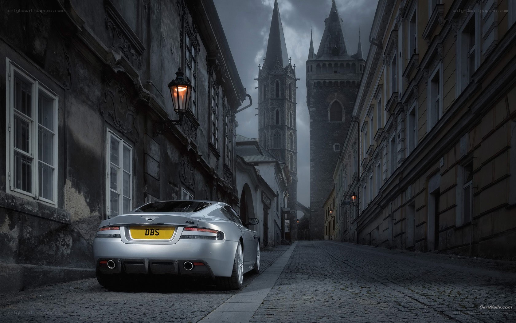 Silver car on cobblestone street