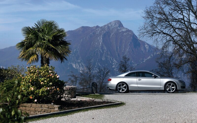 Silver car on gravel with mountain view